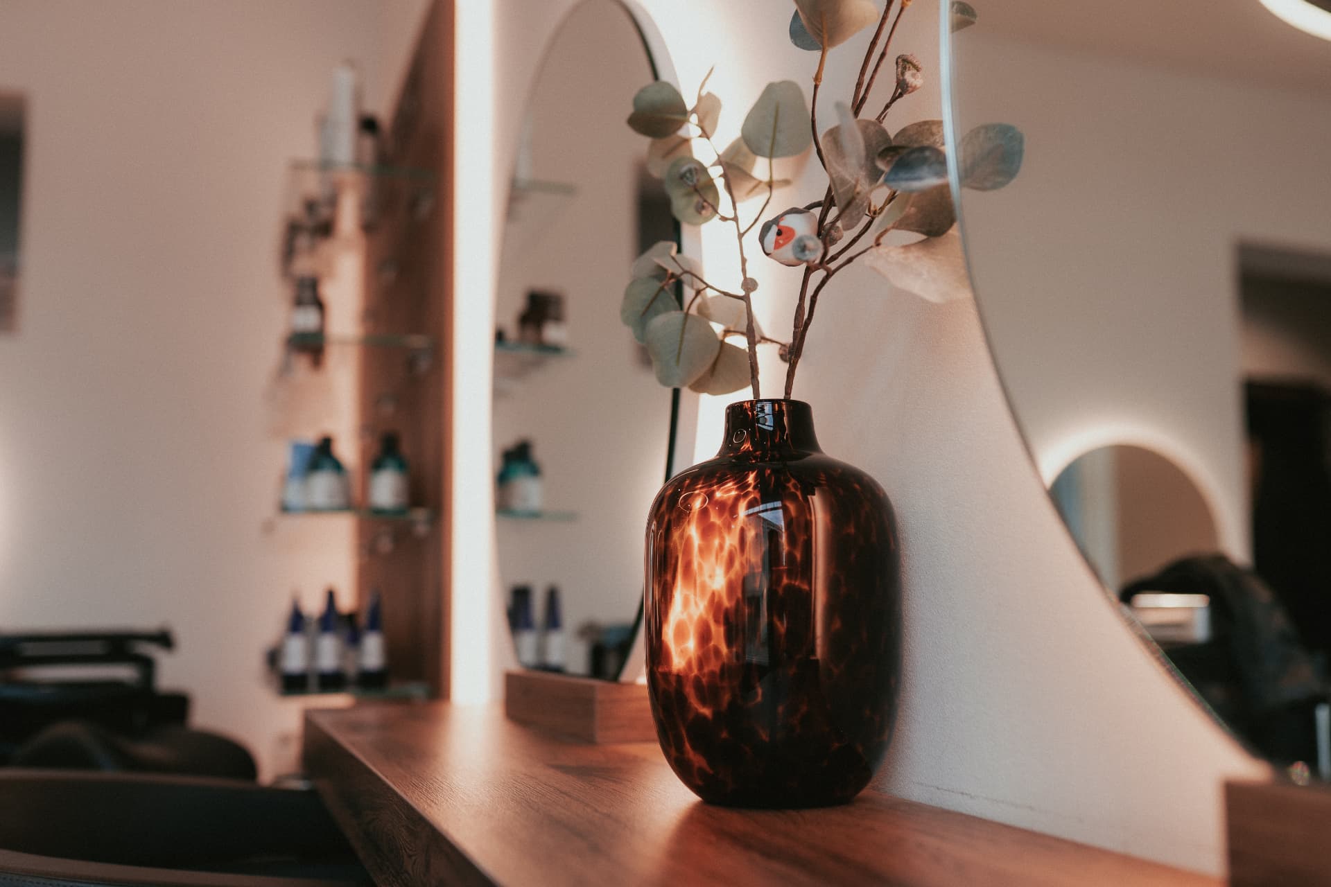 Friseursalon – ausgestattete Stylingplätze mit Spiegeln und Holzablage